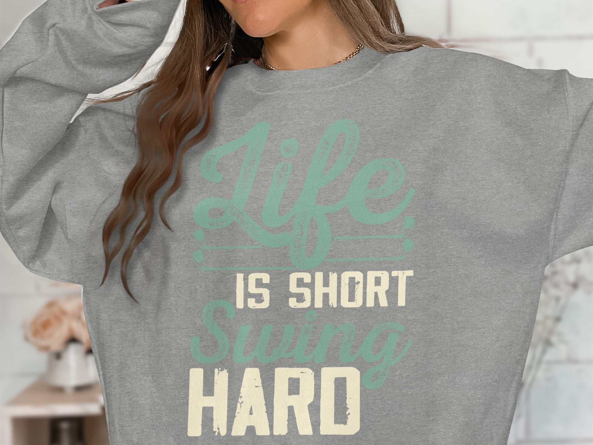 Grey sweatshirt with "Life is Short Swing Hard" text.