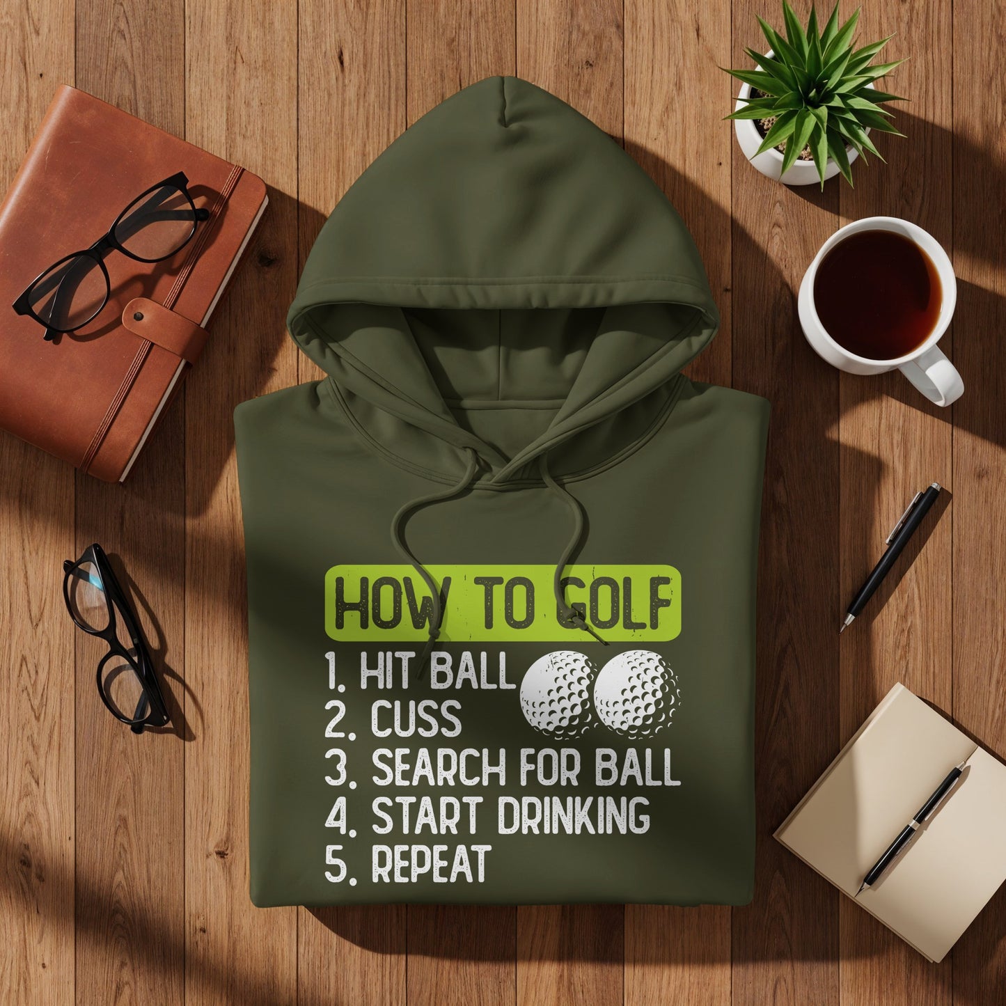 Green hoodie with humorous "How to Golf" text and two golf balls.
