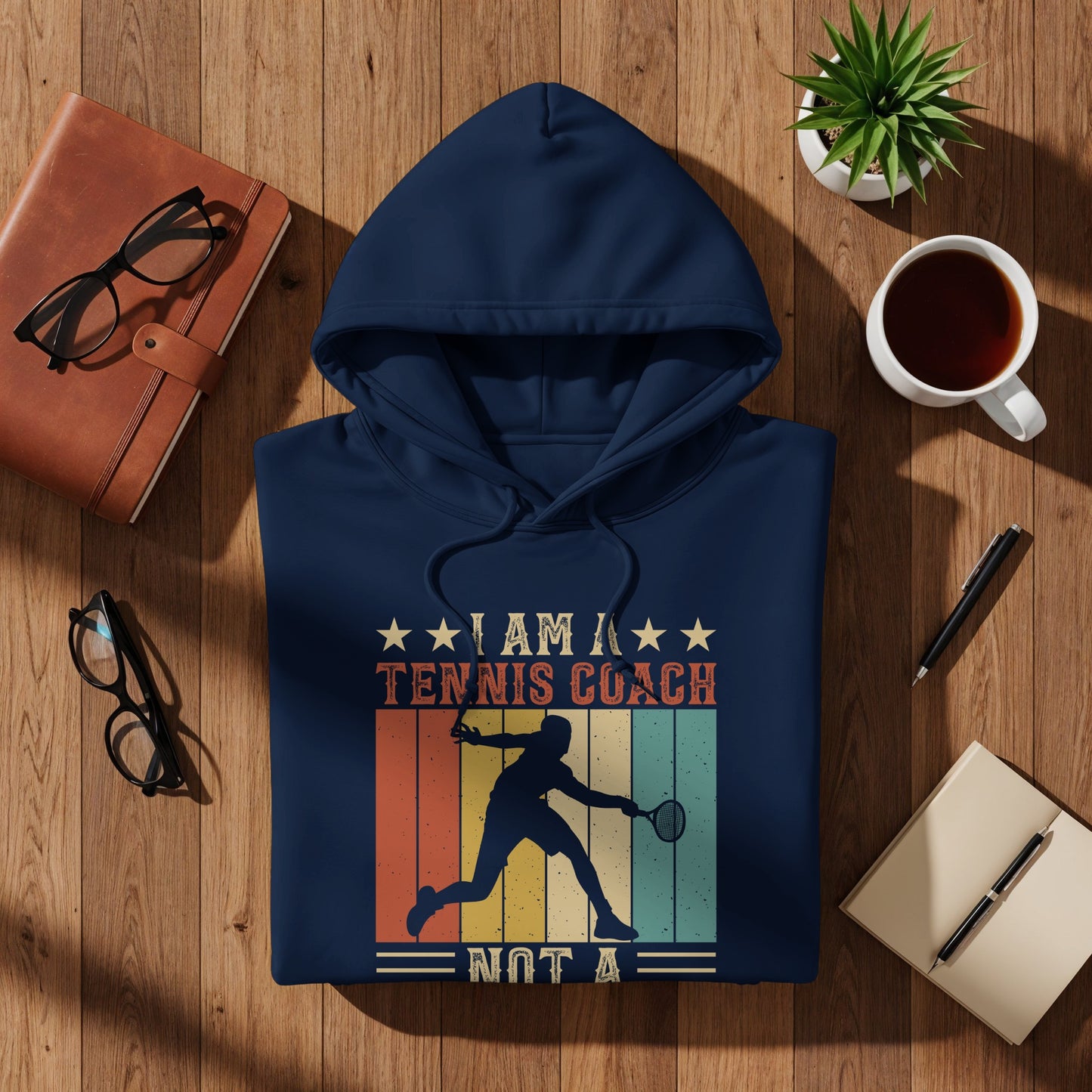 Navy hoodie with "I am a tennis coach not a" graphic.