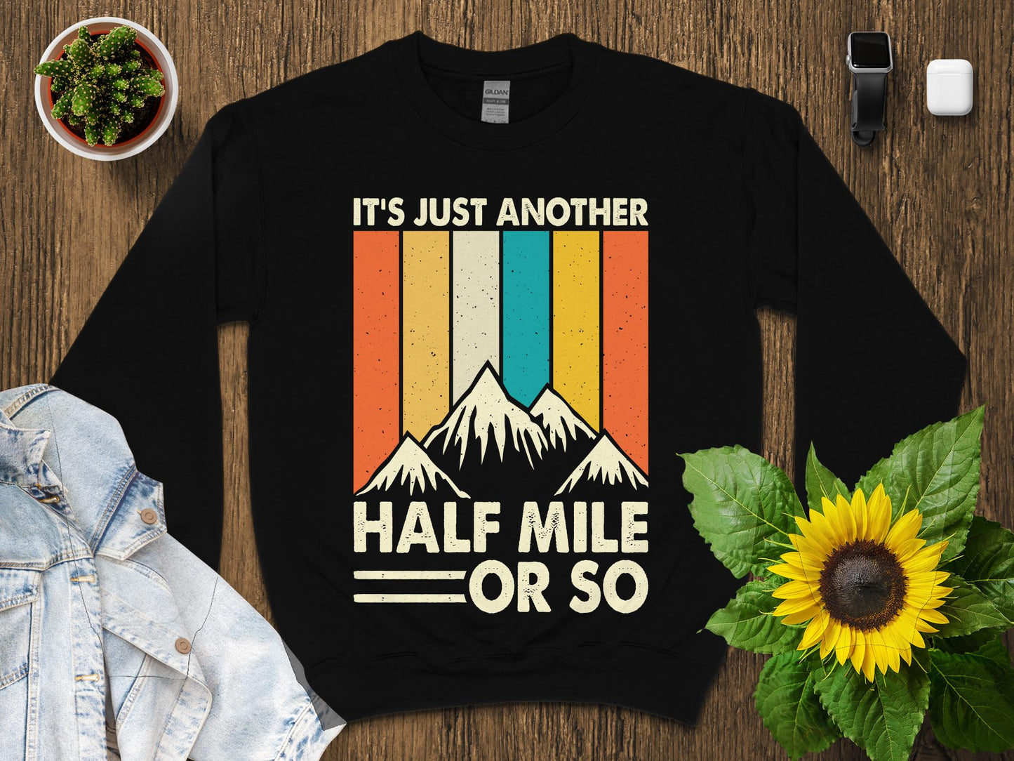 Black sweatshirt with vintage mountain design and text "IT'S JUST ANOTHER HALF MILE OR SO".