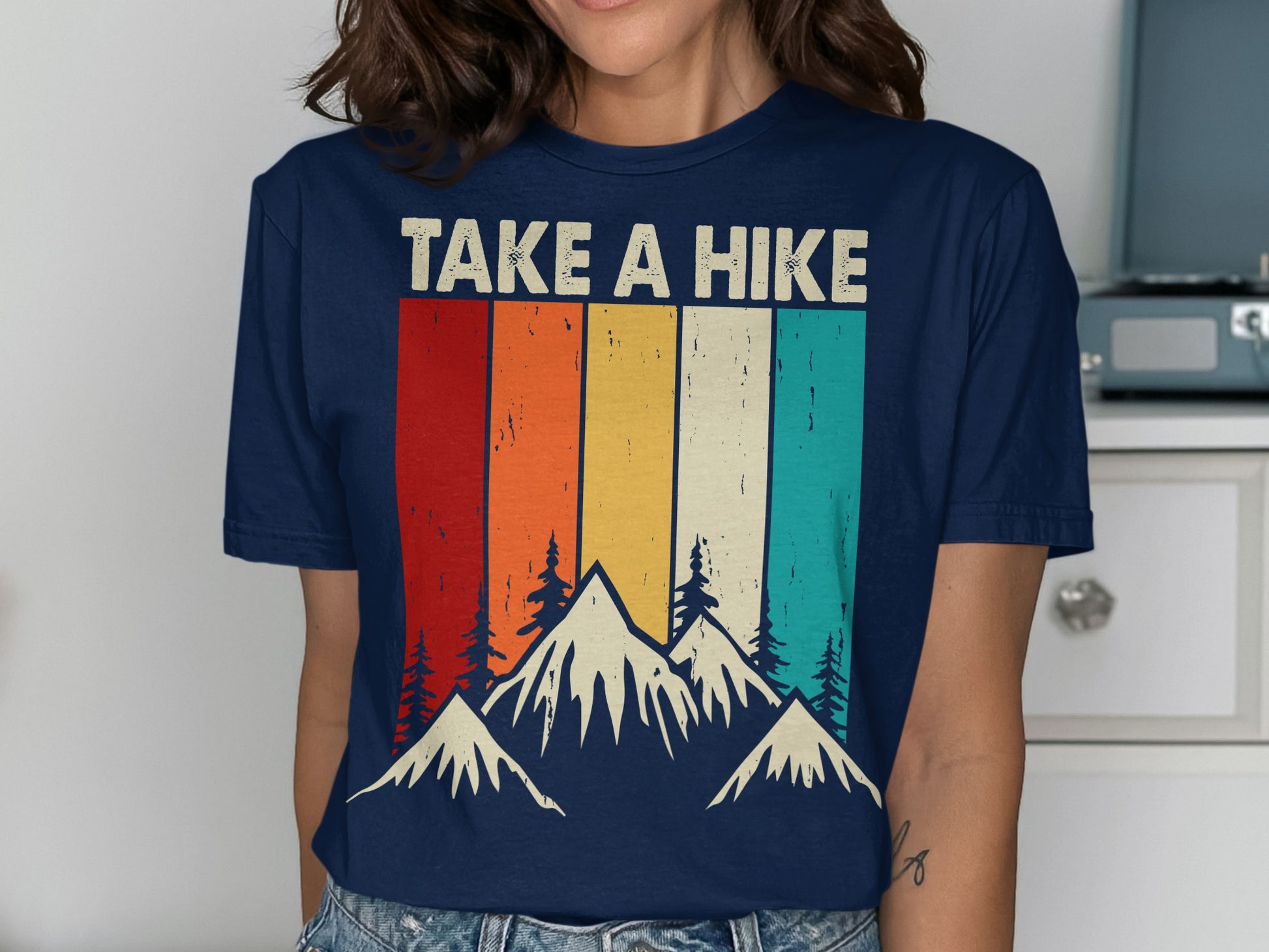 T-shirt with striped sunset and mountain graphic, text "TAKE A HIKE".