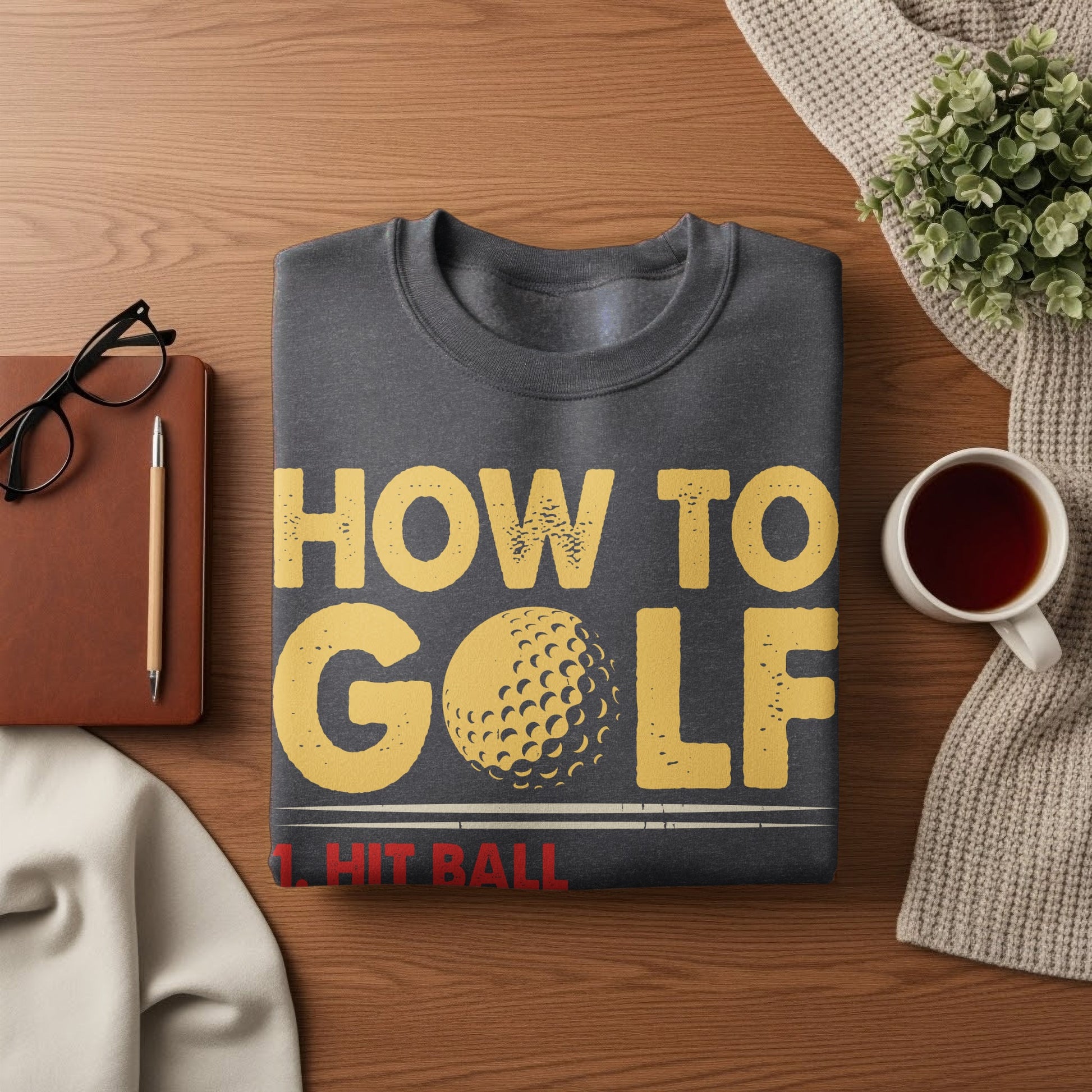 Dark gray sweatshirt with "HOW TO GOLF 1. HIT BALL" in yellow text.