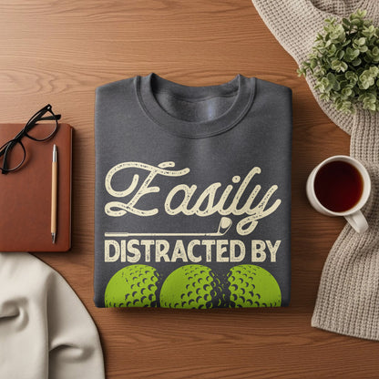 Dark gray sweatshirt with "Easily Distracted By" and golf balls design.