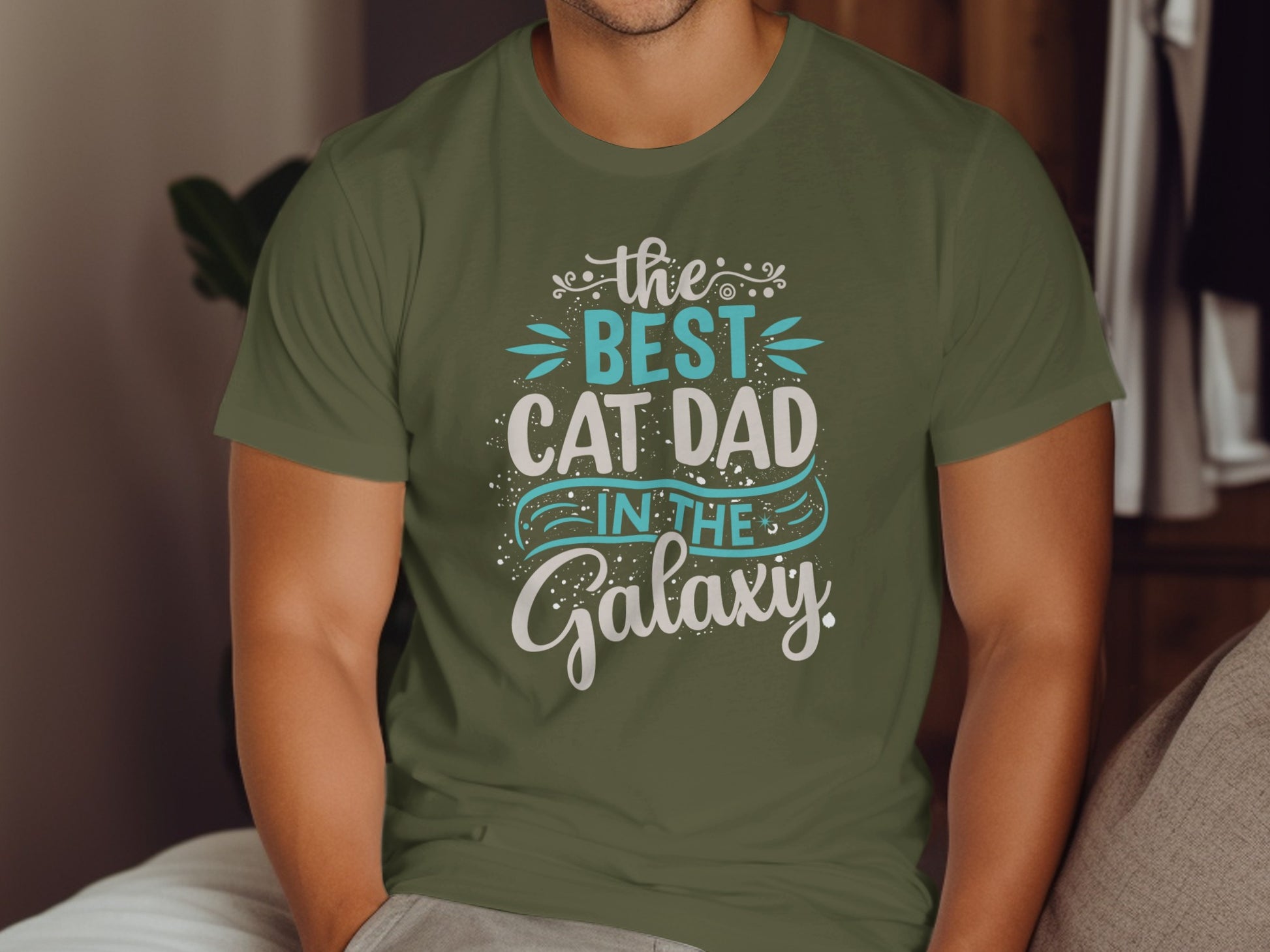Green t-shirt with "the best cat dad in the galaxy" text.