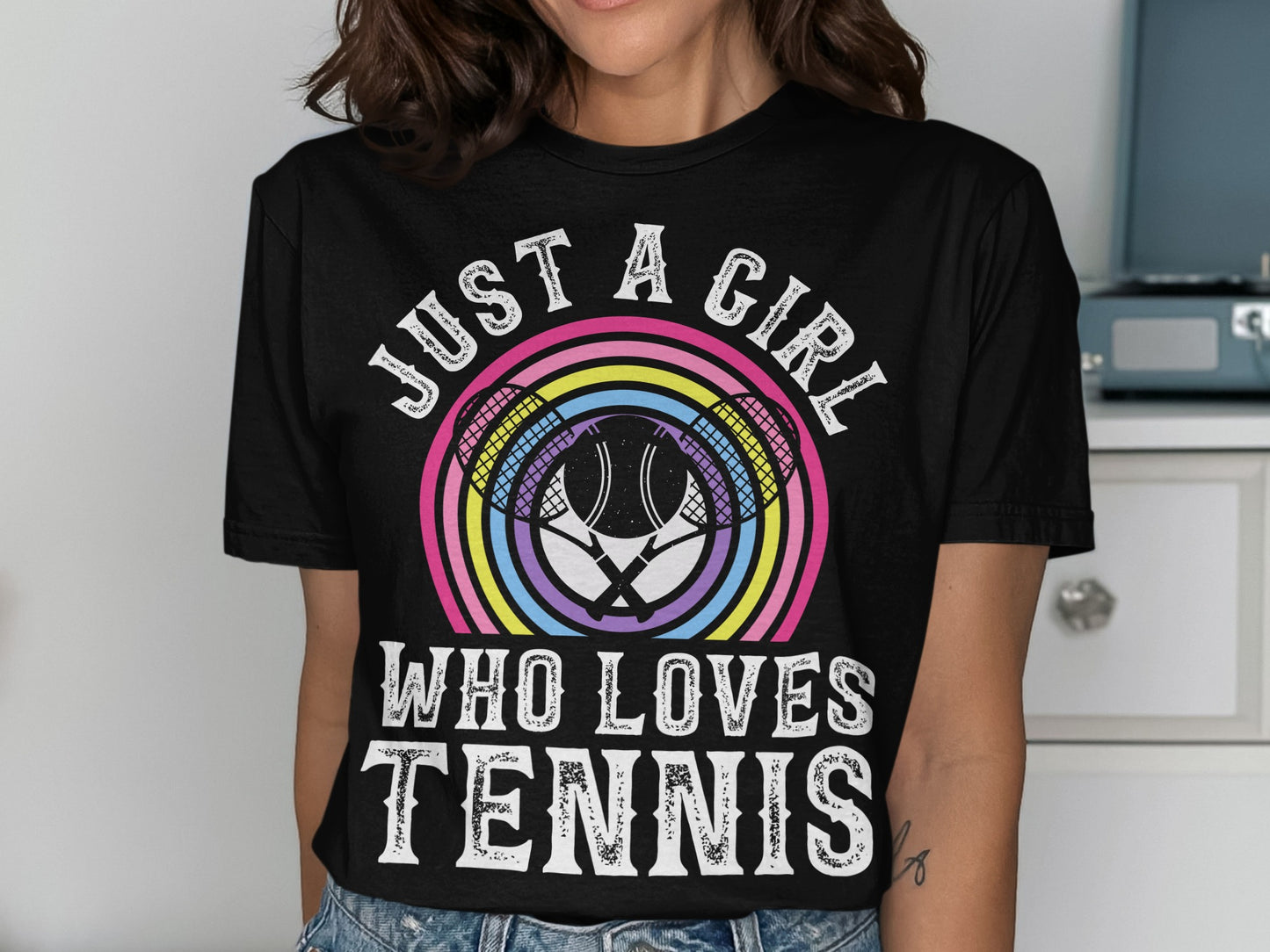 Black t-shirt with rainbow tennis rackets and "JUST A GIRL WHO LOVES TENNIS" text.