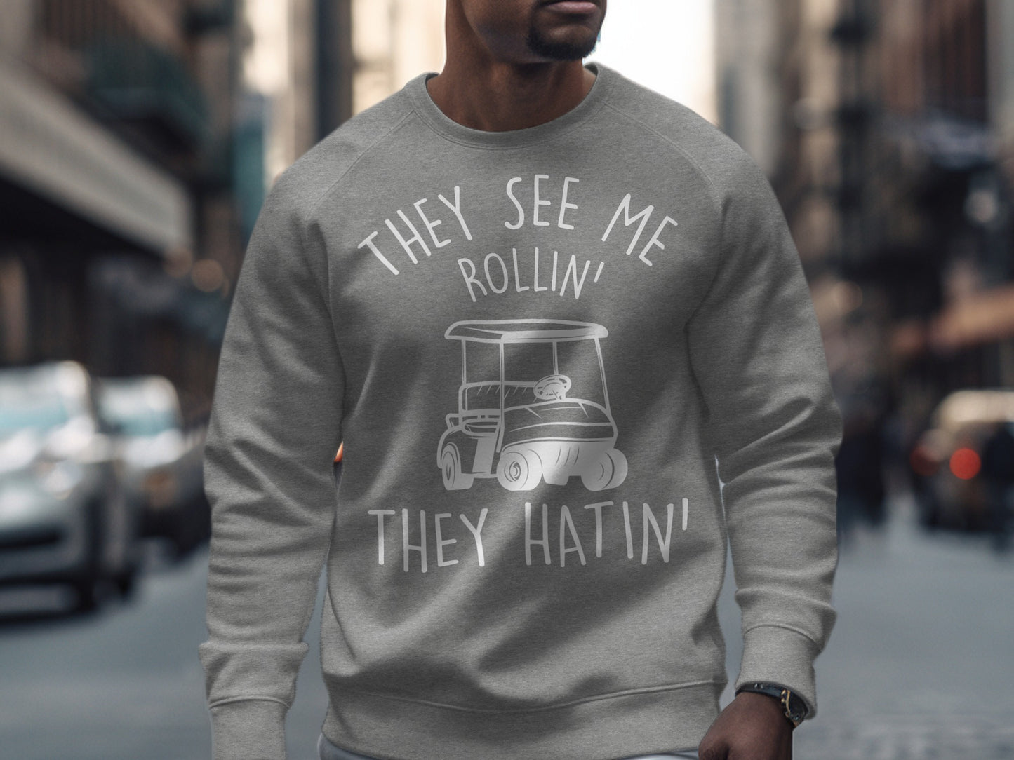 Grey sweatshirt with "They see me rollin' they hatin'" and golf cart graphic.