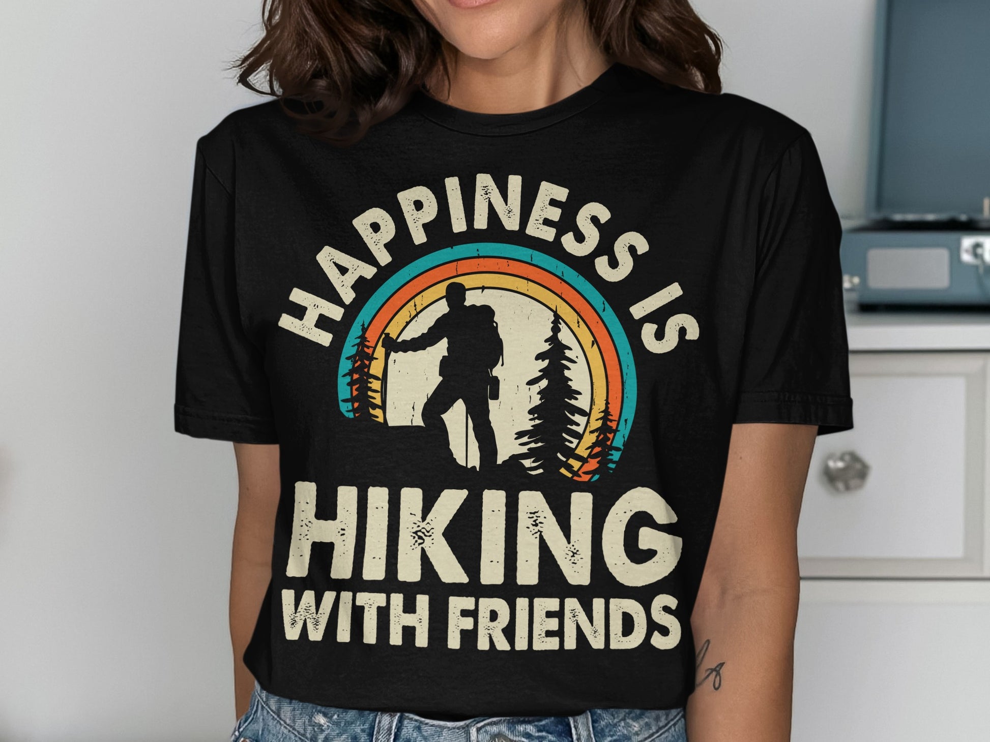 Black t-shirt with "Happiness is Hiking with Friends" and a rainbow hiker graphic.