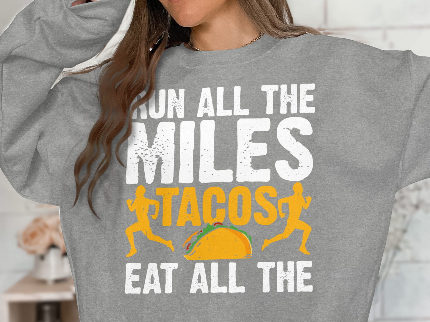 Gray sweatshirt with "Run all the miles, eat all the tacos" text and running figures.