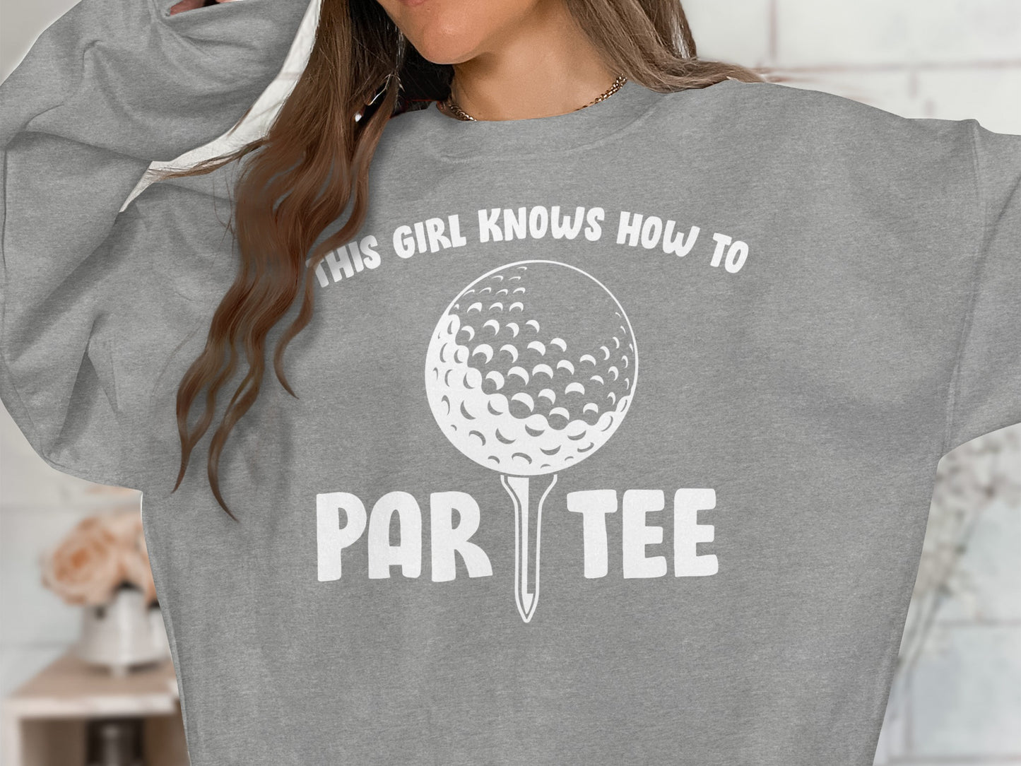 Gray sweatshirt with golf ball and tee graphic and text "This girl knows how to par tee".