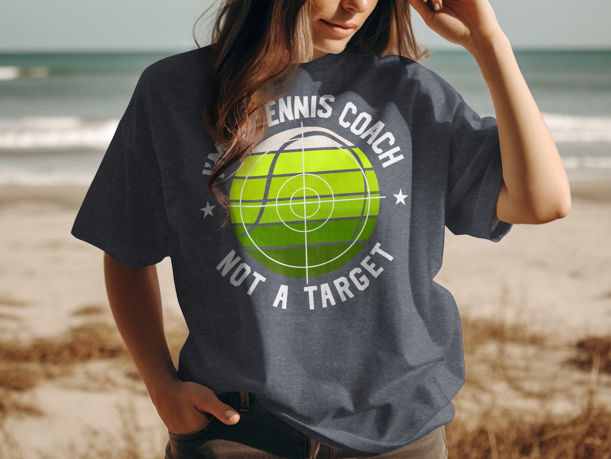 Dark t-shirt with green tennis ball and text "TENNIS COACH NOT A TARGET".