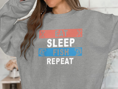 Grey sweatshirt with "EAT SLEEP FISH REPEAT" text and fish graphics.