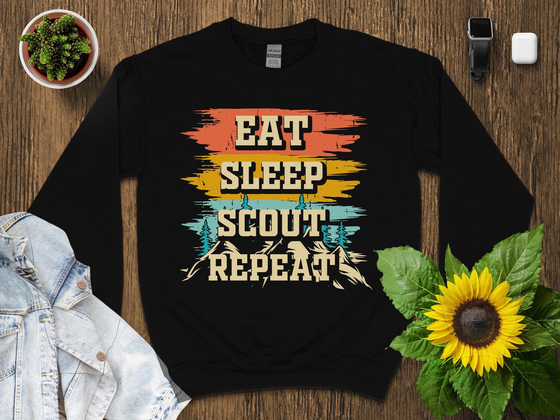 Black crewneck sweatshirt with "Eat Sleep Scout Repeat" vintage mountain design.