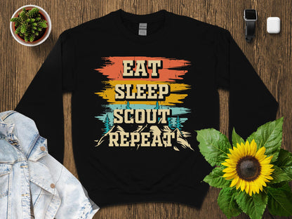 Black crewneck sweatshirt with "Eat Sleep Scout Repeat" vintage mountain design.