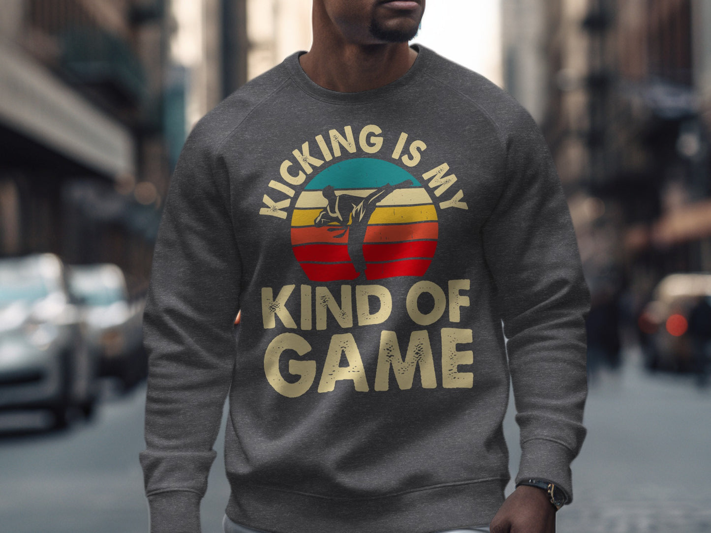 Man wearing a gray sweatshirt with a circular graphic that reads "Kicking is my kind of game."