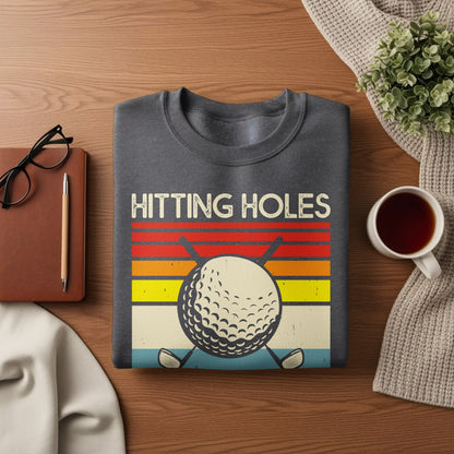 Grey sweatshirt with "HITTING HOLES" text and a golf ball.