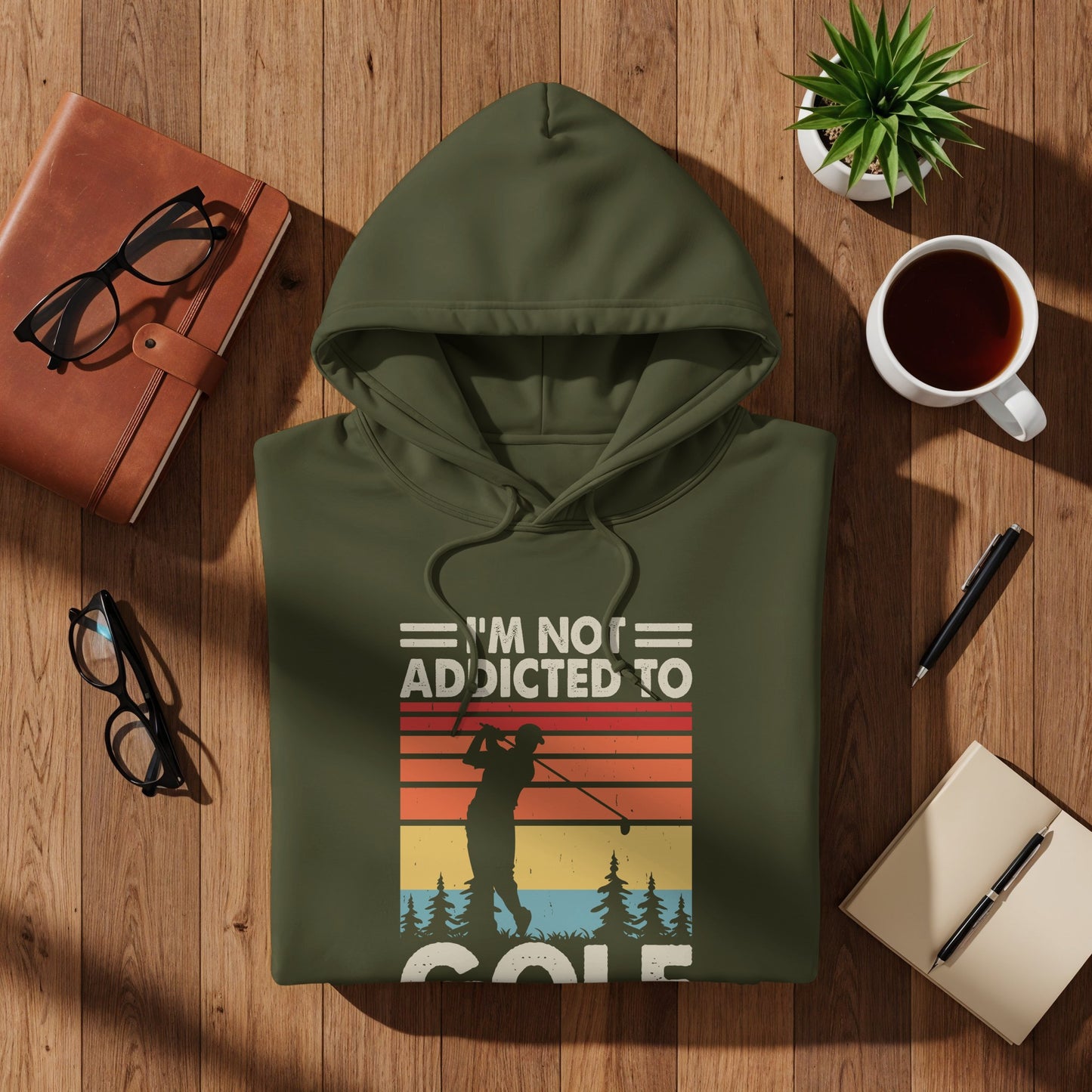 Olive green hoodie with text "I'm not addicted to golf" and a golfer silhouette.