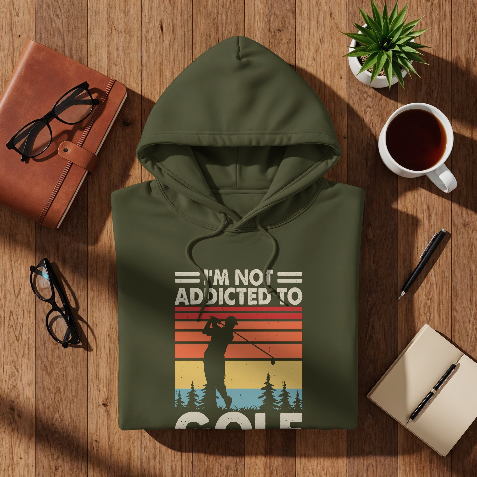 Olive green hoodie with text "I'm not addicted to golf" and a golfer silhouette.