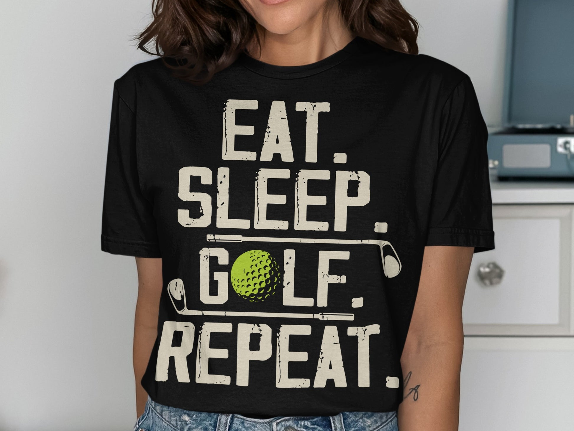 Black t-shirt with "EAT. SLEEP. GOLF. REPEAT." text and golf ball.
