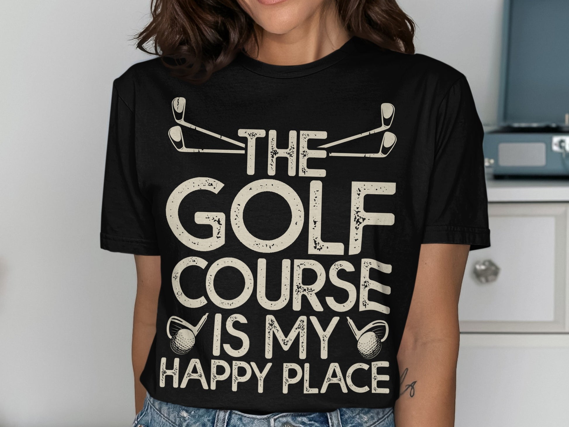 Black t-shirt with "The Golf Course Is My Happy Place" text and golf club graphics.