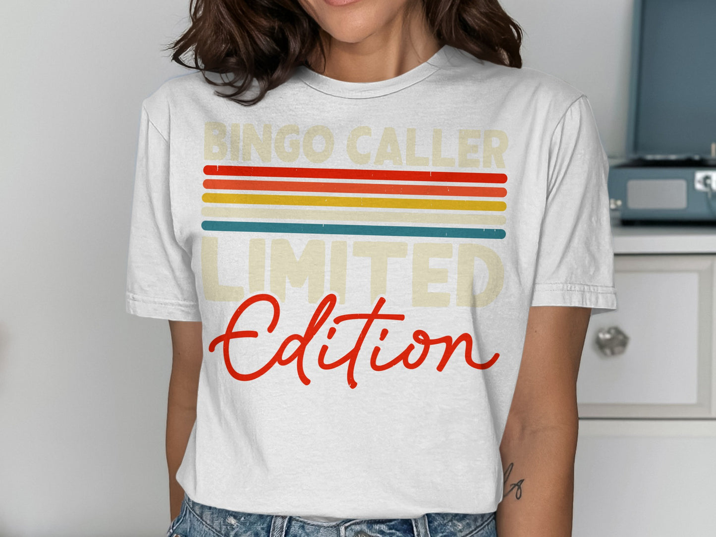 White t-shirt with "Bingo Caller Limited Edition" in colorful retro stripes.