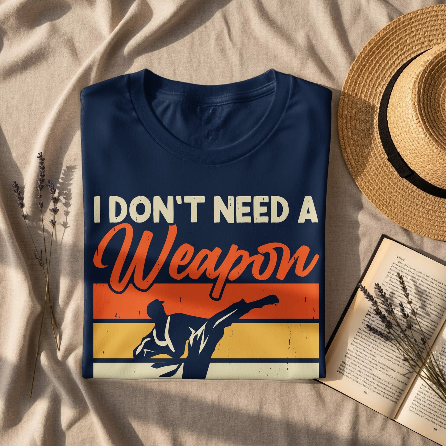 Dark blue t-shirt with "I DON'T NEED A Weapon" and martial artist graphic.