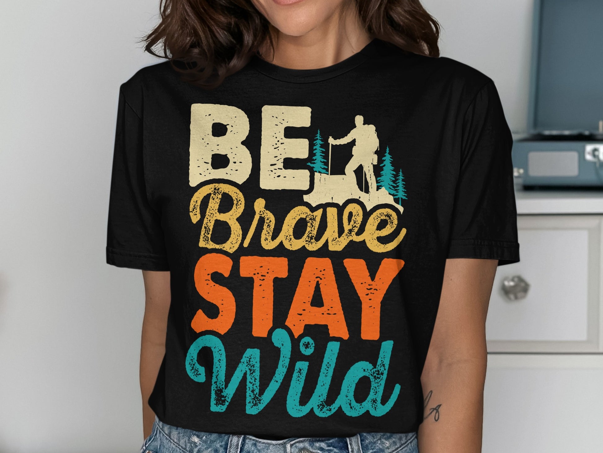 BE Brave STAY Wild text with hiker silhouette and trees graphic.