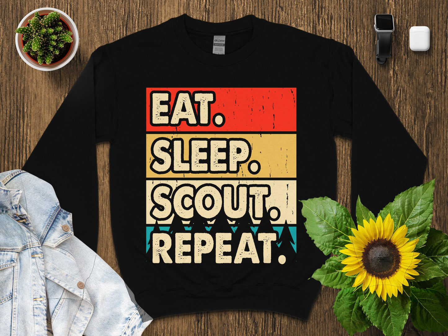 Black sweatshirt with "Eat. Sleep. Scout. Repeat." text in retro style.