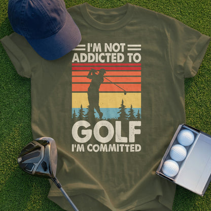 Olive t-shirt with text "I'm Not Addicted to Golf I'm Committed" and a golf sunset graphic.