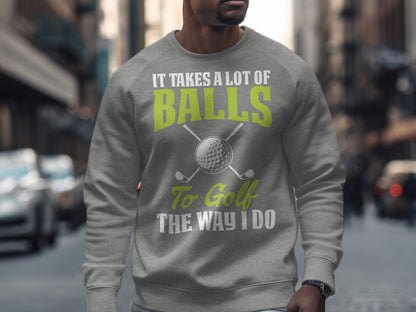 Grey sweatshirt with "IT TAKES A LOT OF BALLS TO GOLF THE WAY I DO" and golf clubs.