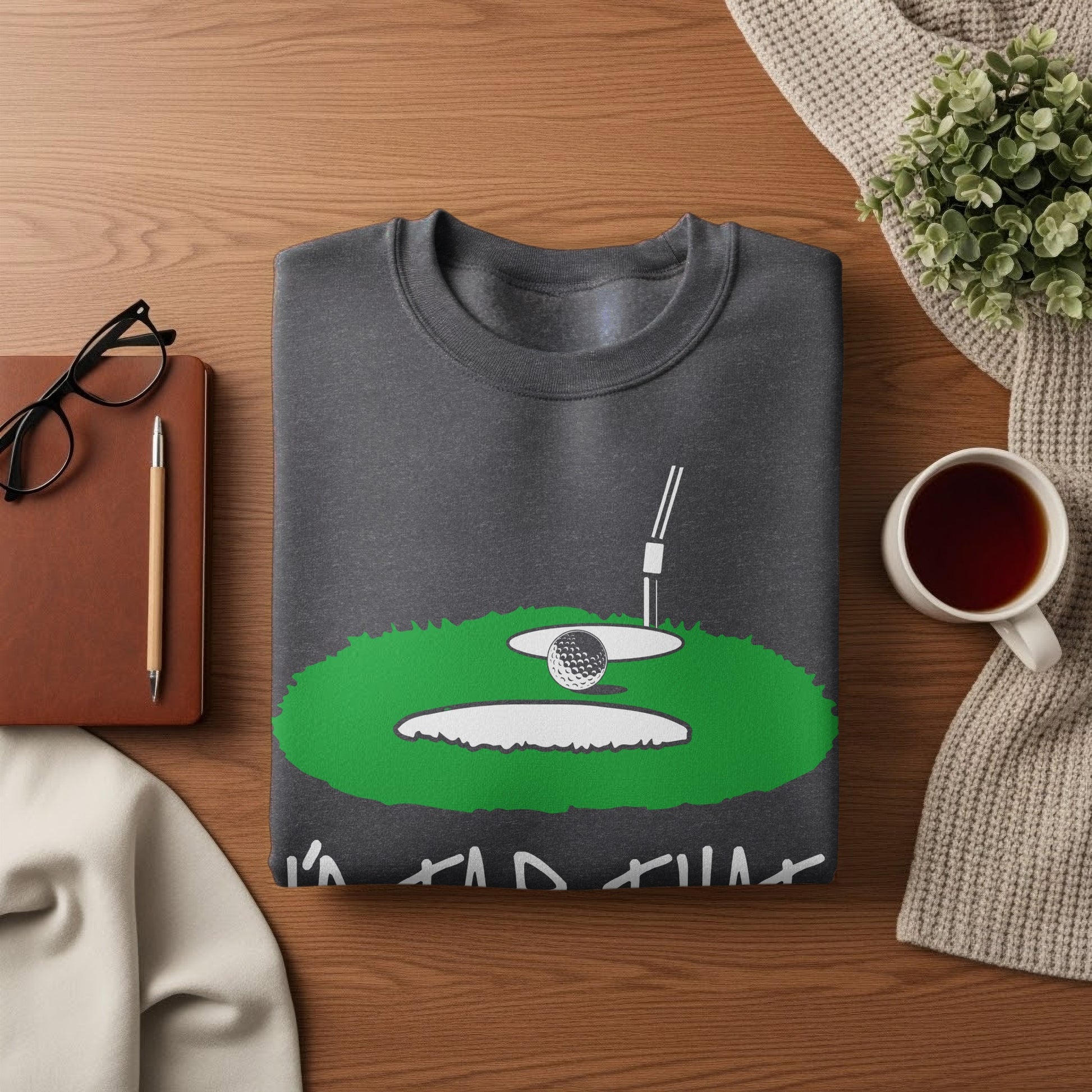 Dark gray sweatshirt with a graphic of a golf ball in a sand trap.