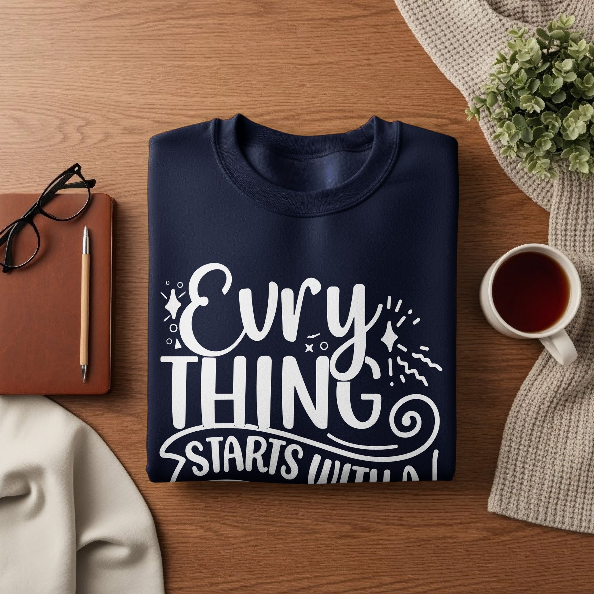 Navy sweatshirt with white text "Evry thing starts with".