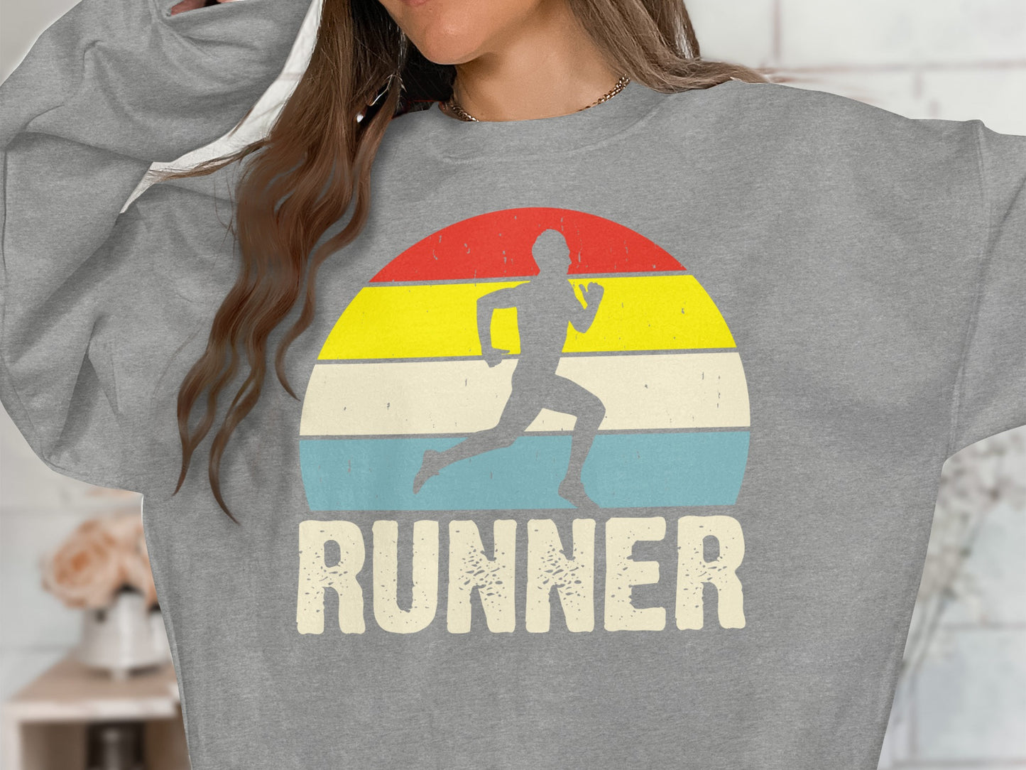 Gray sweatshirt with running silhouette and "RUNNER" text on striped background.