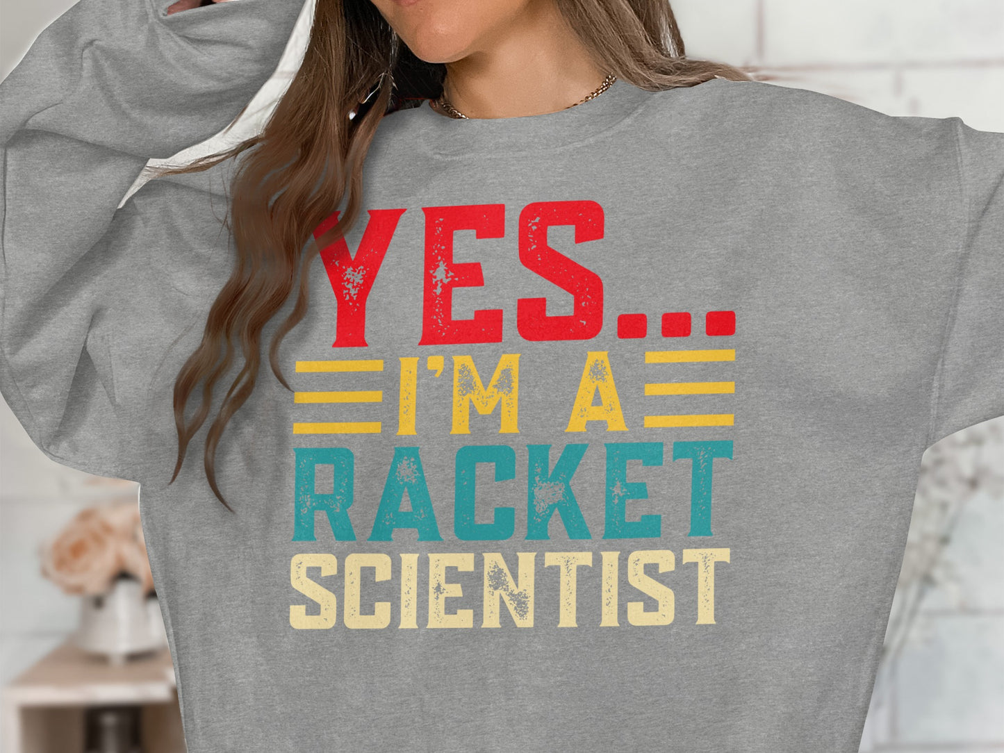 Grey sweatshirt with "YES... I'M A RACKET SCIENTIST" graphic text.