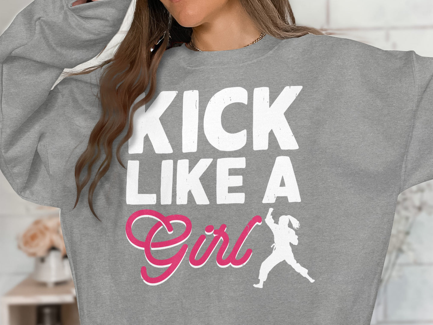 Gray sweatshirt with white text "KICK LIKE A GIRL" and pink graphic.