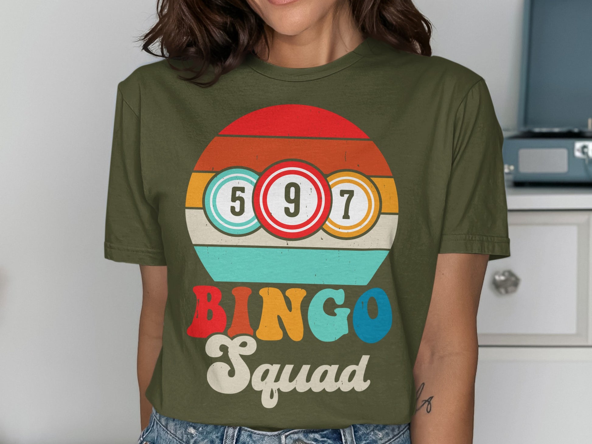 Olive green t-shirt with "BINGO Squad" text and bingo balls.