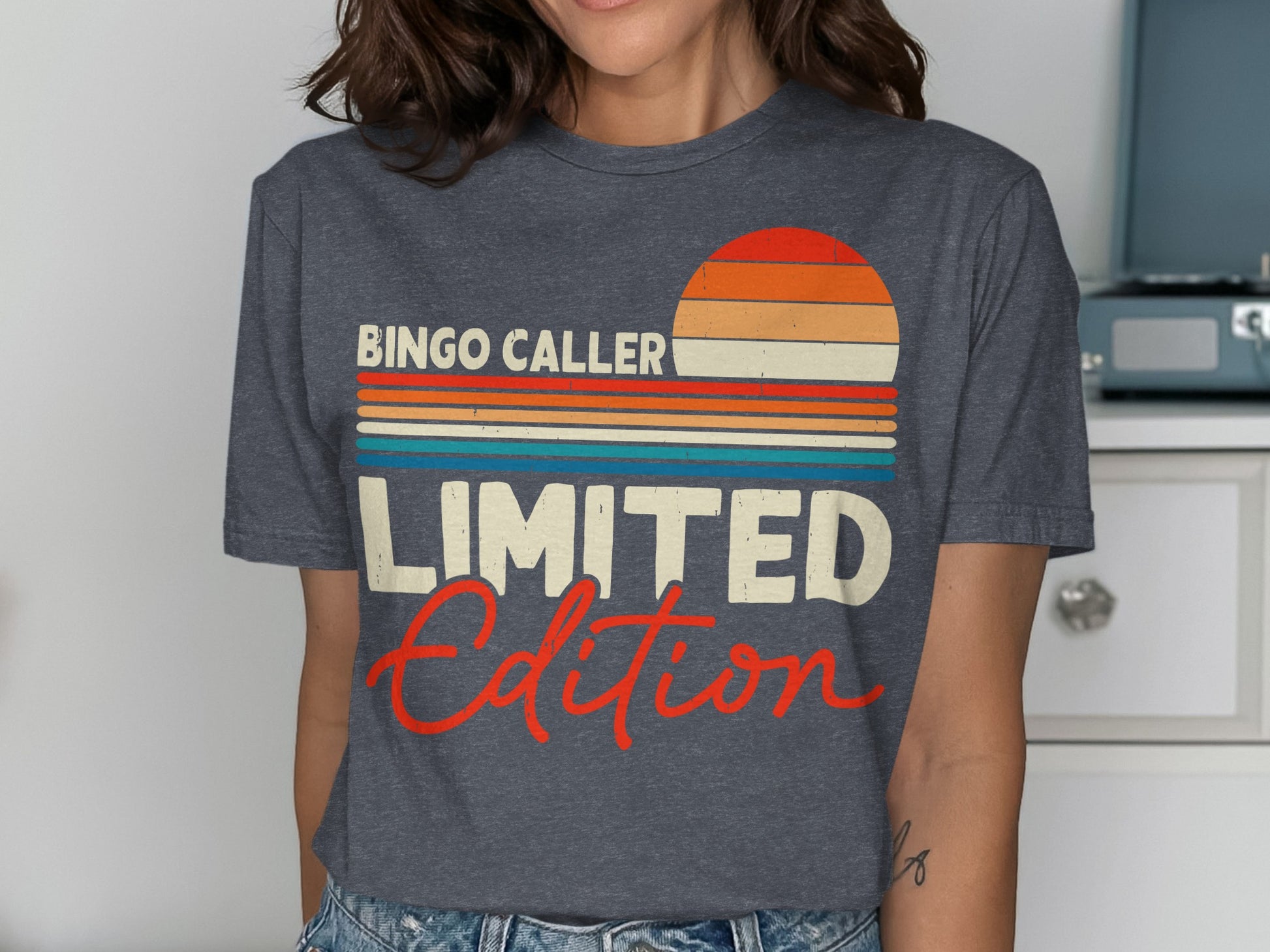 T-shirt with "BINGO CALLER LIMITED EDITION" text and retro sunset design.