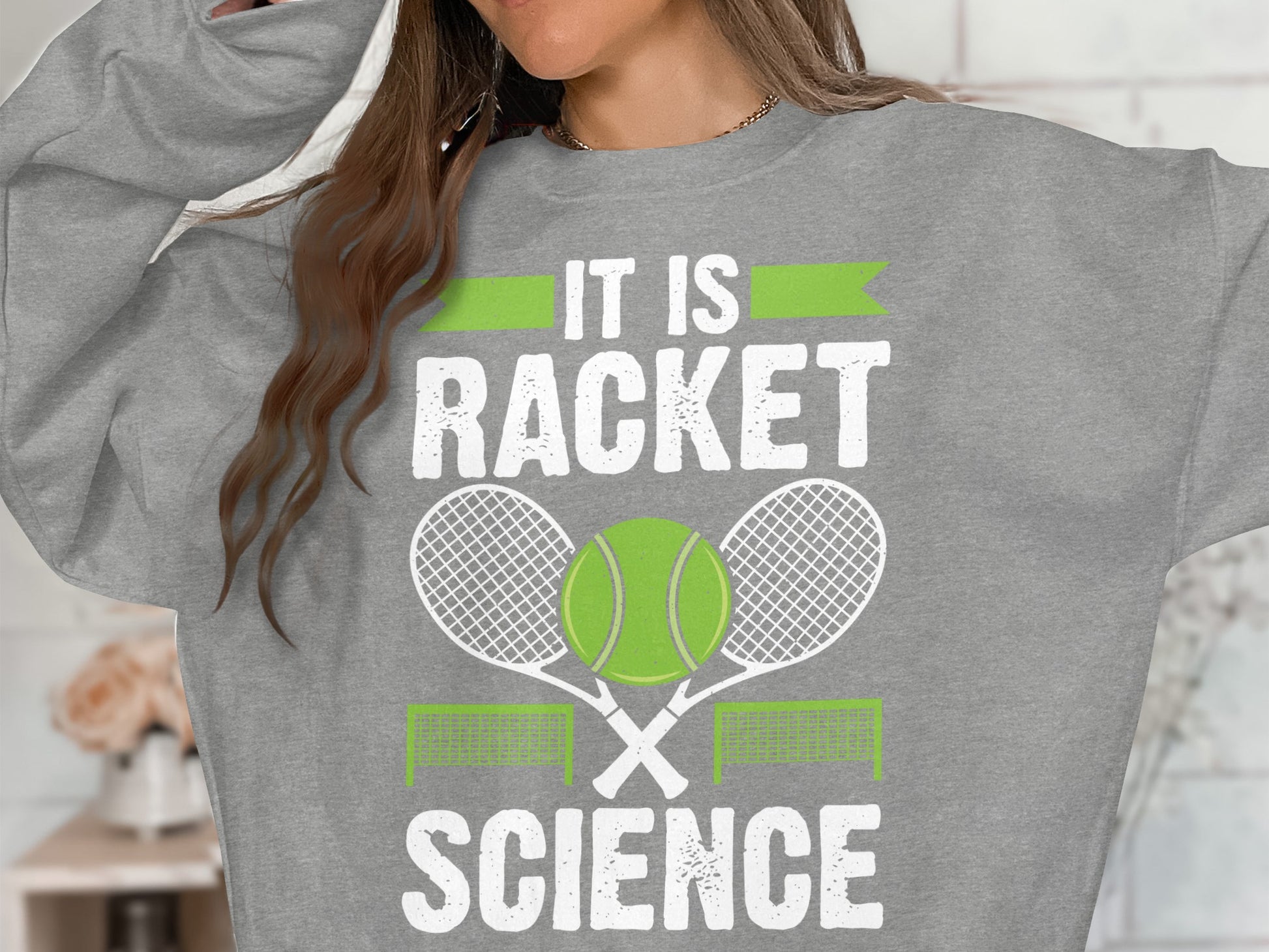 Grey sweatshirt with "It is Racket Science" text and tennis graphics.