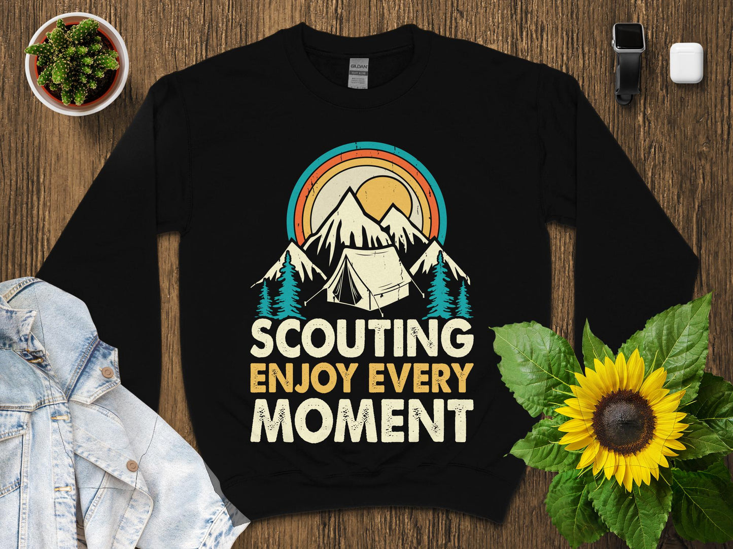 Black sweatshirt with "Scouting Enjoy Every Moment" text and mountain sunset graphic.