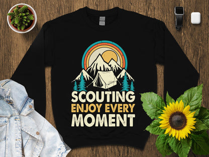 Black sweatshirt with "Scouting Enjoy Every Moment" text and mountain sunset graphic.