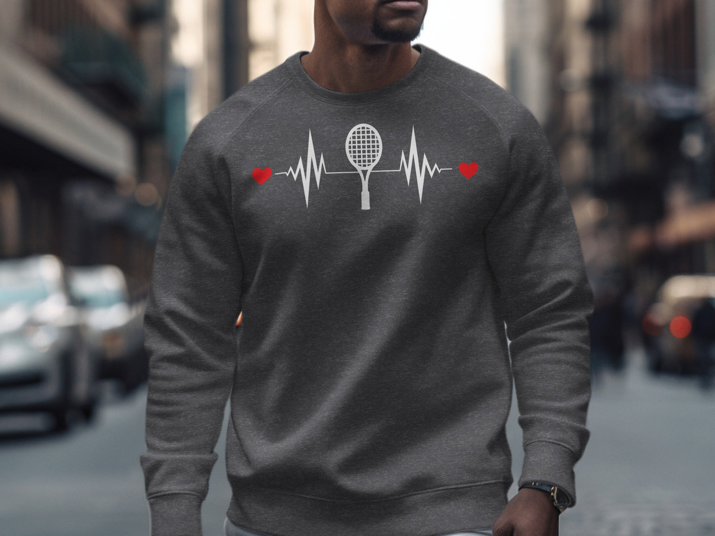 Man wearing a dark grey sweatshirt with a tennis racket and heartbeat graphic.