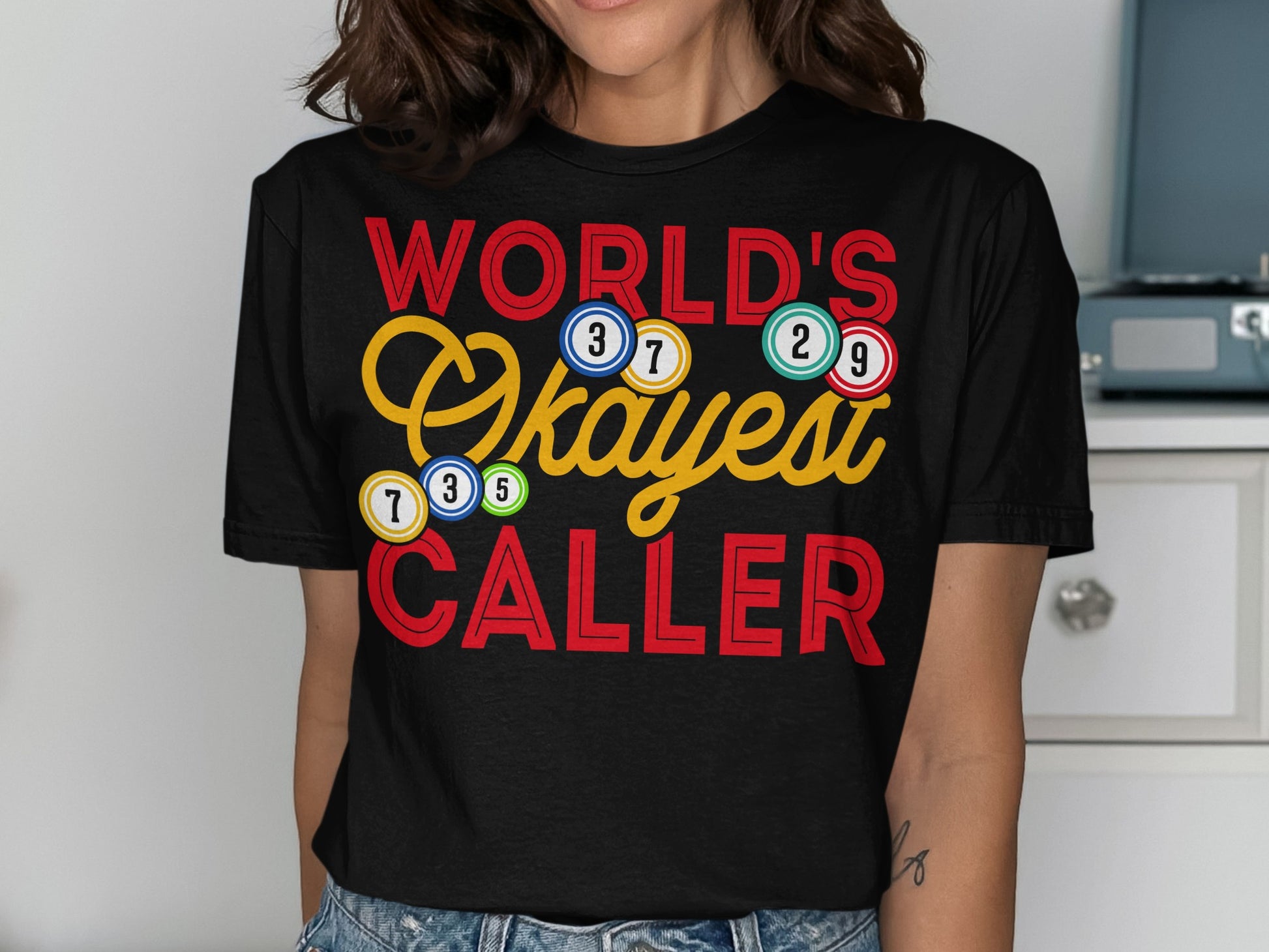Black t-shirt with "World's Okayest Caller" and bingo balls.