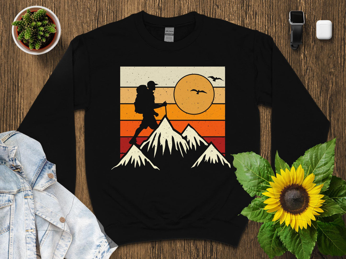 Black sweatshirt with vintage hiker silhouette on mountains graphic.