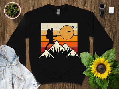 Black sweatshirt with vintage hiker silhouette on mountains graphic.
