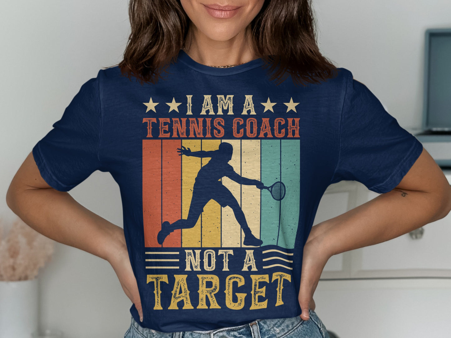 Navy t-shirt with "I Am A Tennis Coach Not A Target" graphic.