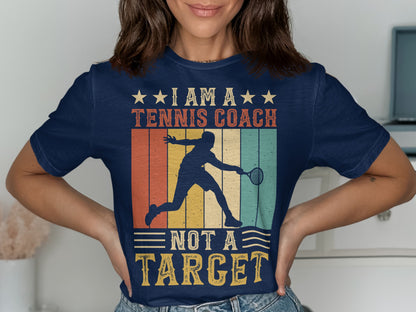 Navy t-shirt with "I Am A Tennis Coach Not A Target" graphic.
