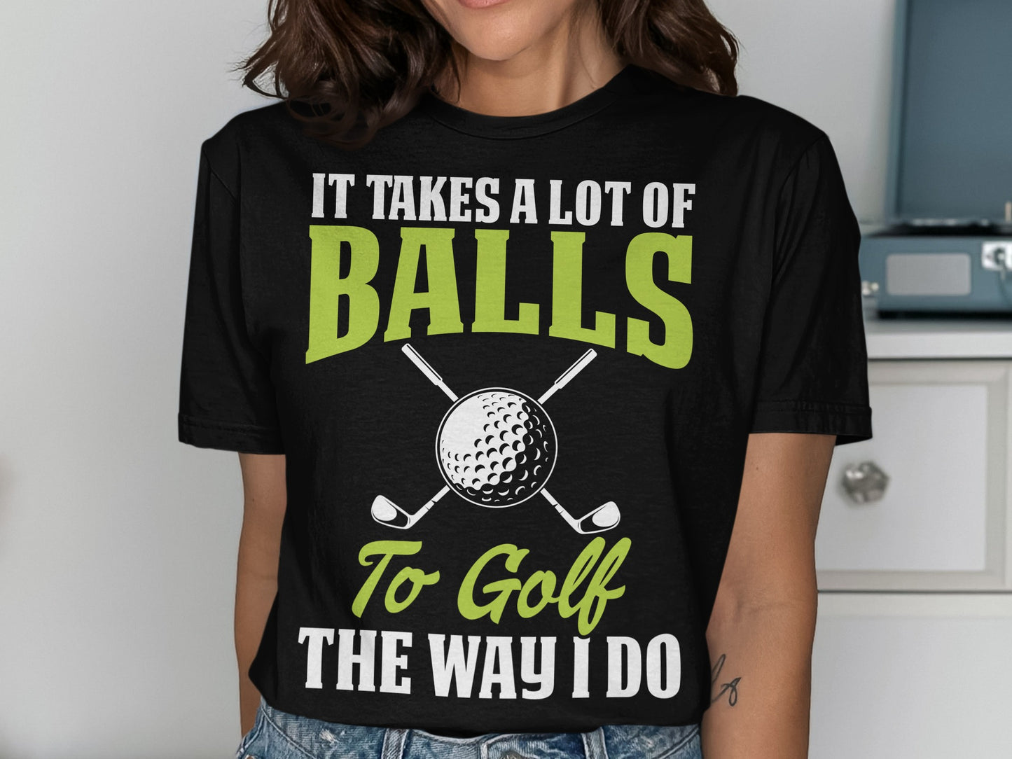 Black t-shirt with "IT TAKES A LOT OF BALLS TO GOLF THE WAY I DO" text and golf club graphic.