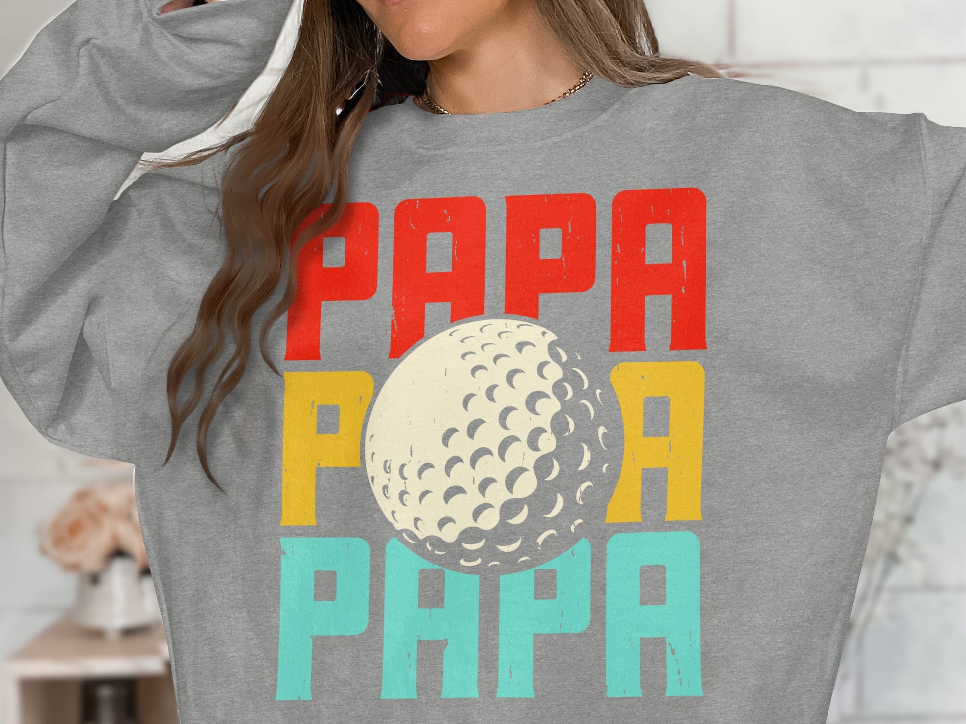 Grey sweatshirt with "PAPA" in red, yellow, and teal, and a golf ball.