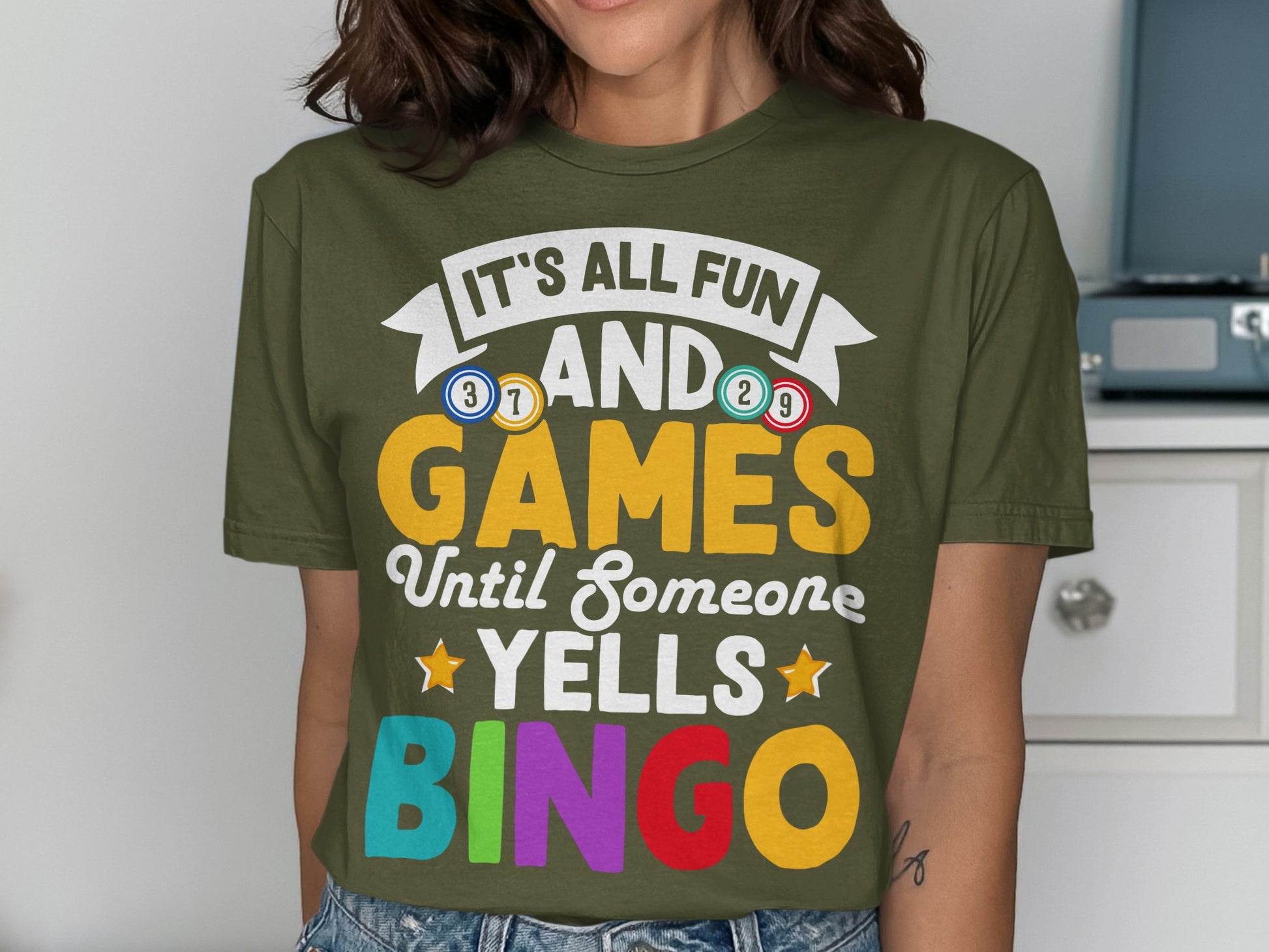 Green t-shirt with "IT'S ALL FUN AND GAMES UNTIL SOMEONE YELLS BINGO".