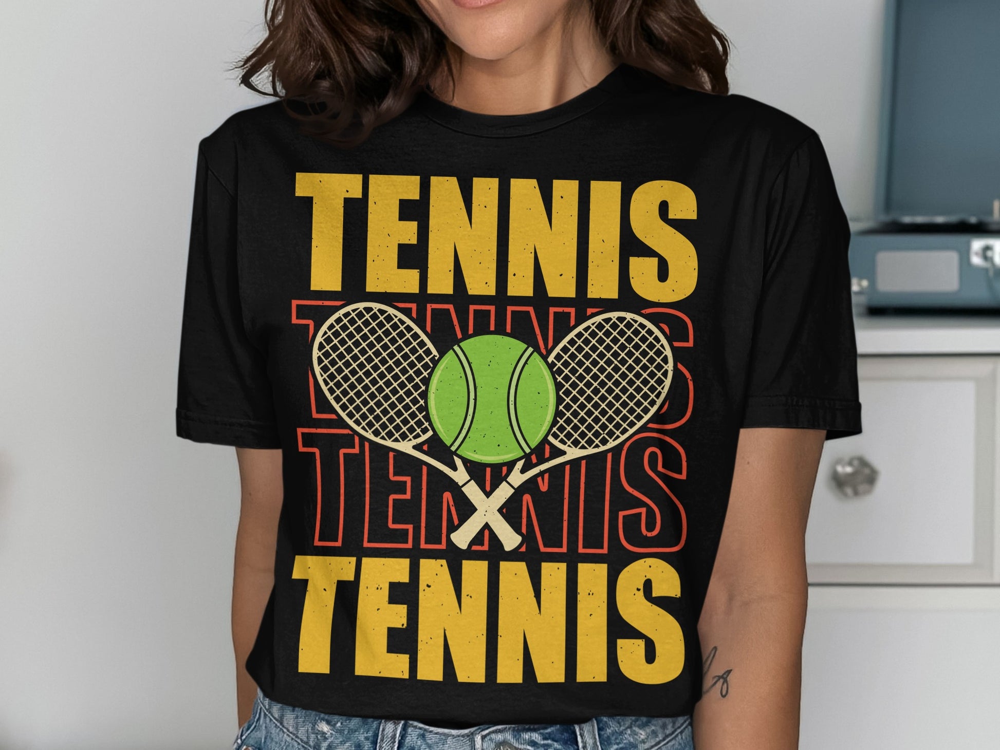 Black t-shirt with "TENNIS" repeated in yellow and orange, and a tennis ball and rackets.