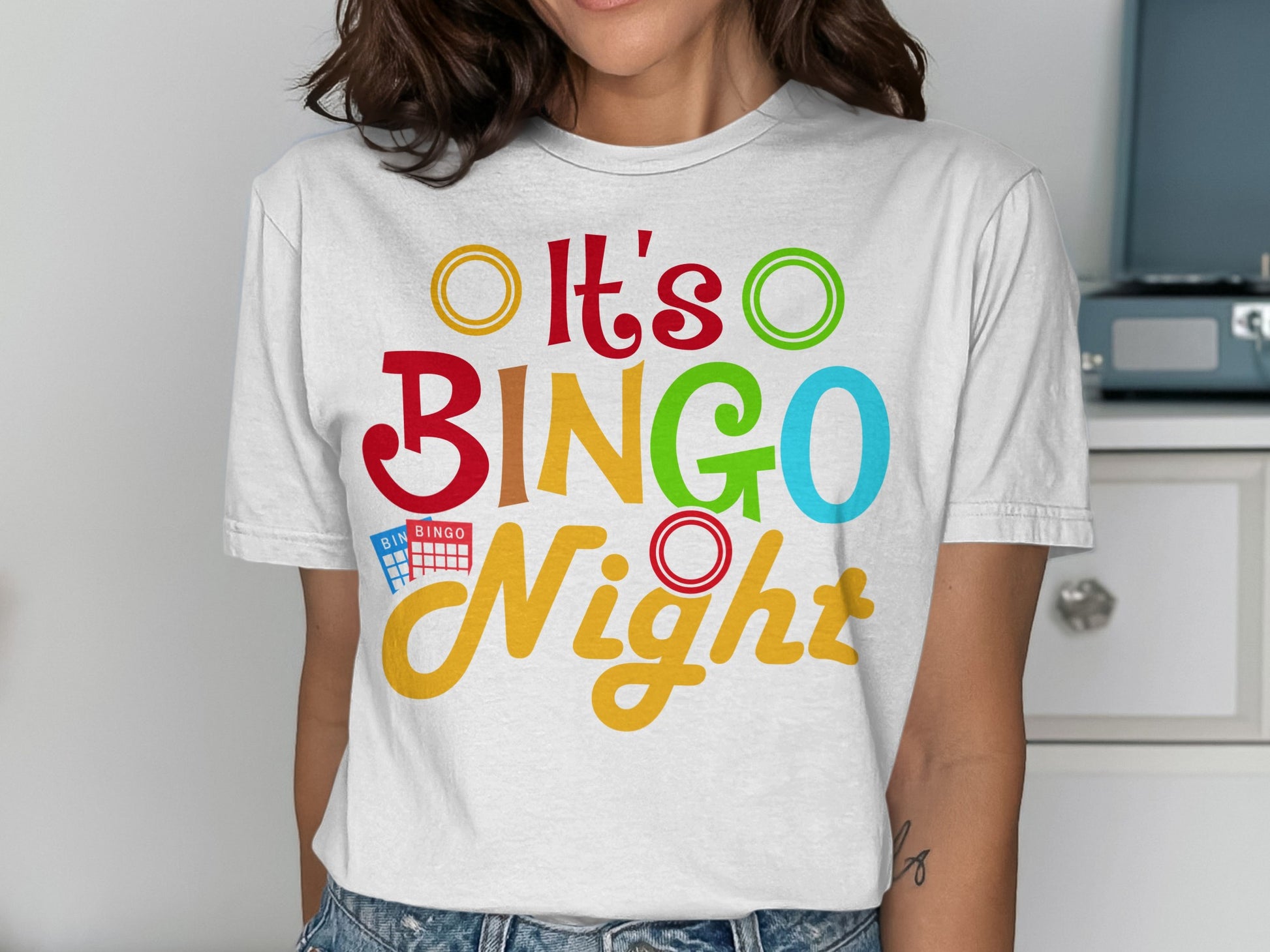 White t-shirt with colorful "It's BINGO Night" text and bingo balls.
